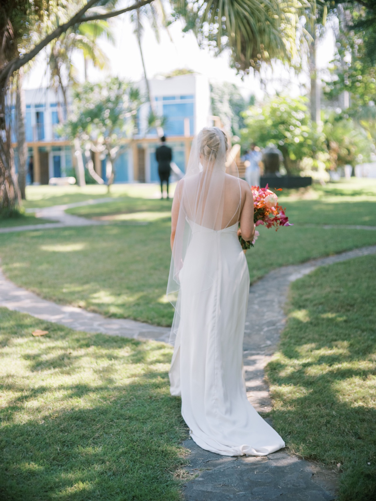 Novia caminando por el sendero del jardín hacia el novio