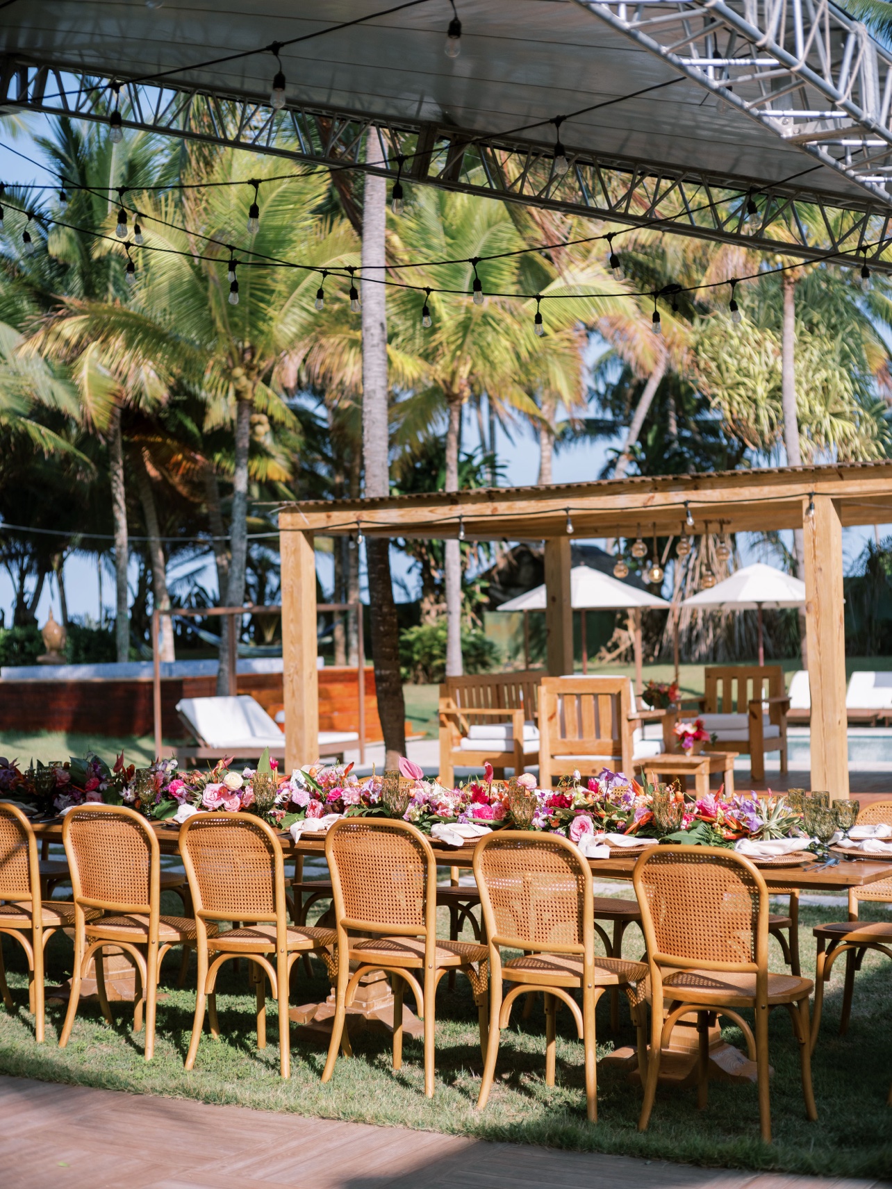 Mesa de recepción con flores tropicales bajo la pérgola entre palmeras