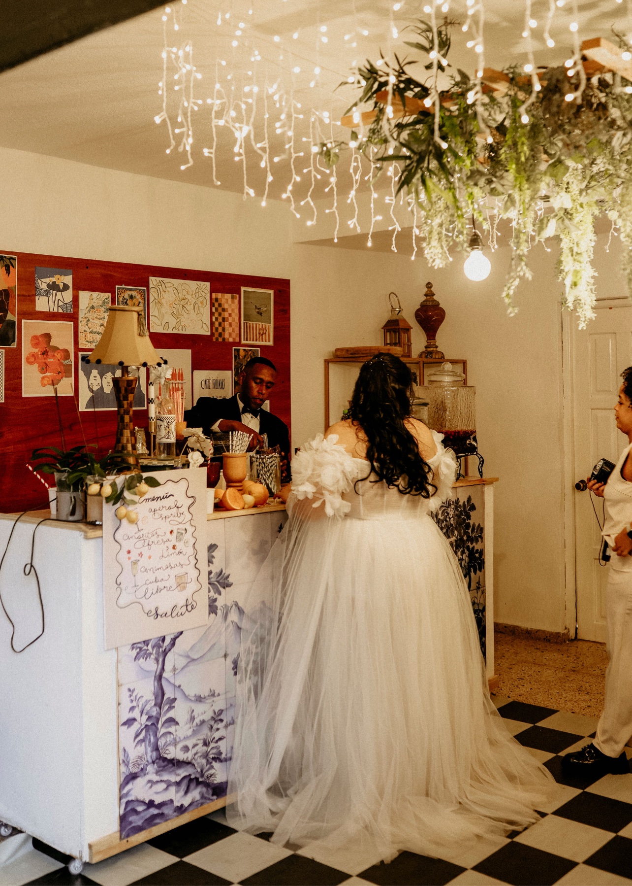 Novia frente a una barra decorada con cerámica azul y luces colgantes