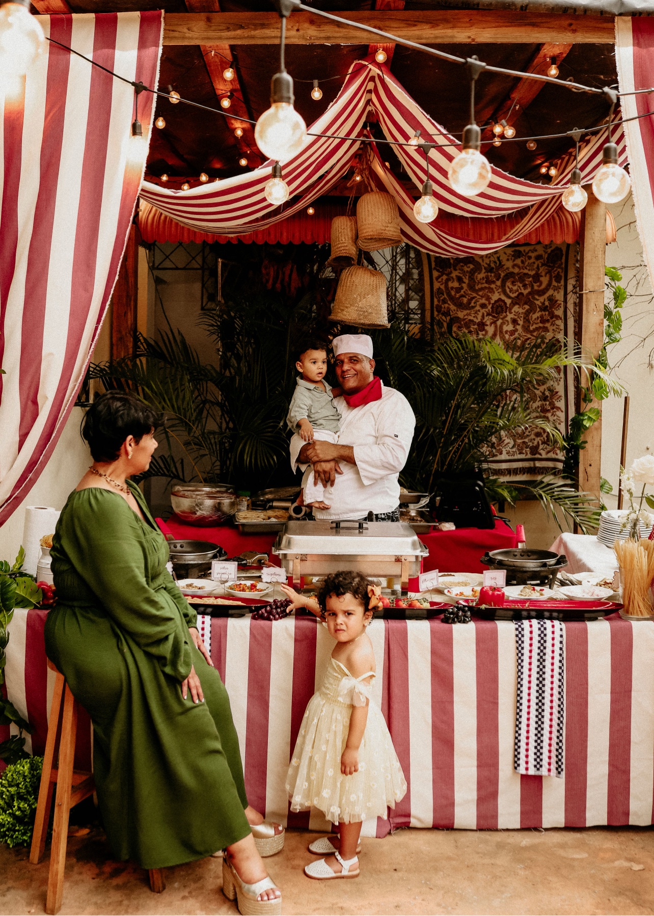 Estación de catering a rayas con el chef y dos niños