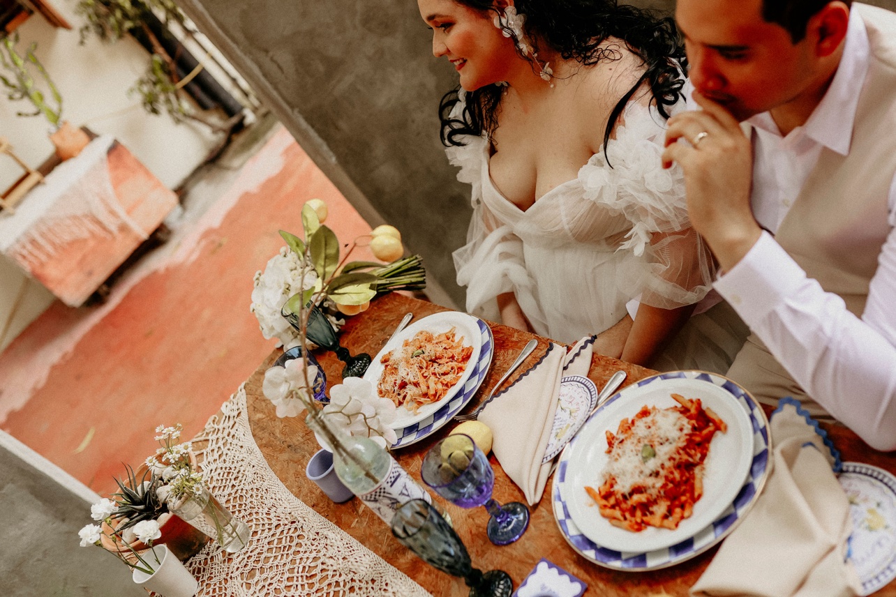 Novios compartiendo la comida en una mesa con vajilla azul