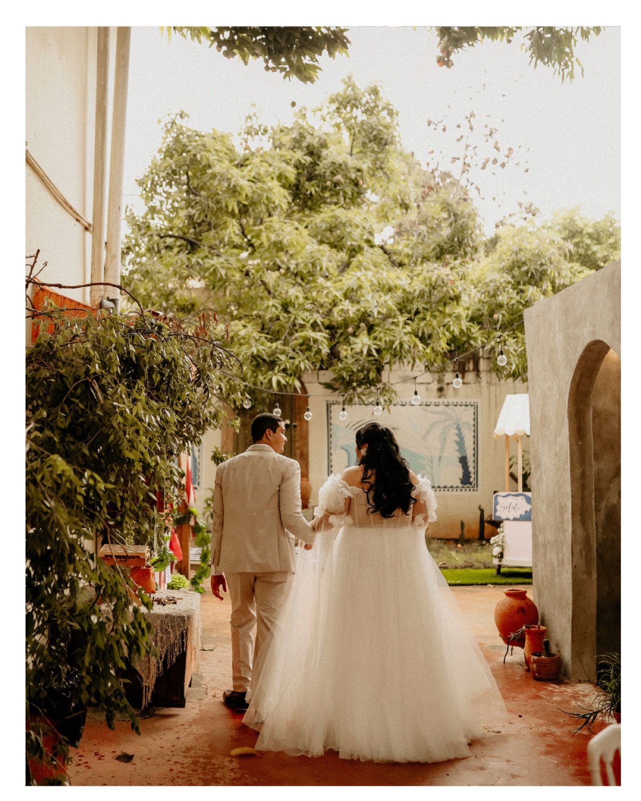 Pareja de recién casados caminando hacia la celebración al aire libre