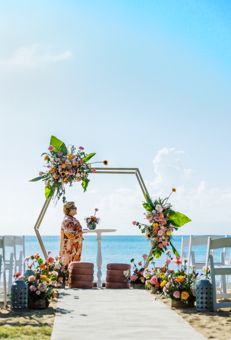 Arco geométrico decorado con flores tropicales frente al mar