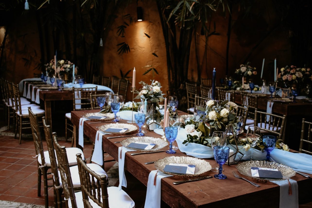 Mesa larga de recepción con velas y flores al atardecer